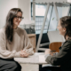 Foto von Illustratorin Nicola Hammerschmied, die gerade ein Interview mit Lisa Lindinger von Scandicted.interiour design über die Einrichtung von Therapieräumen führt.